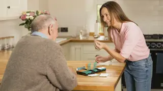 Carent looking after their elderly parent, holding a bag of medication